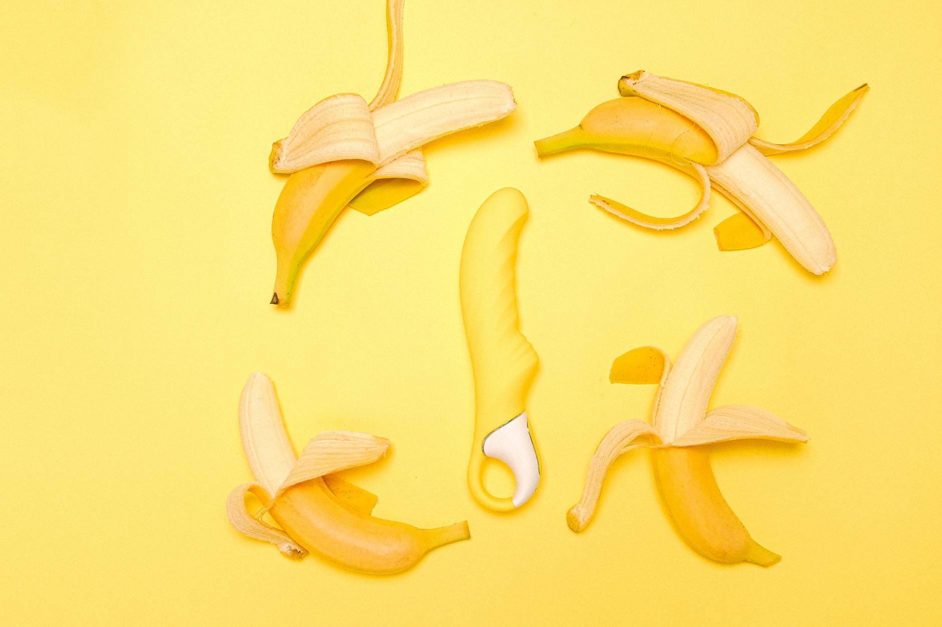 A yellow Lemon vibrator with fresh lemons on a bright background