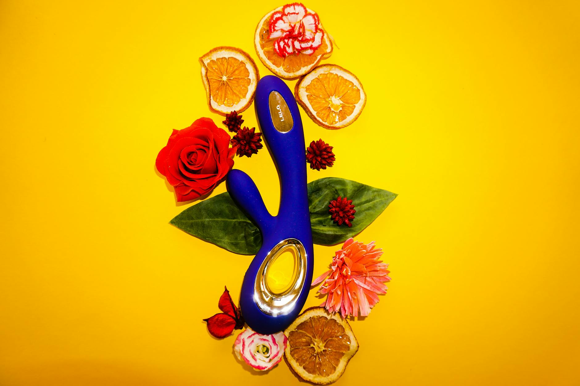 A hand holding a fresh lemon against a vibrant yellow background, symbolizing the natural and approachable design of Lemon Massagers